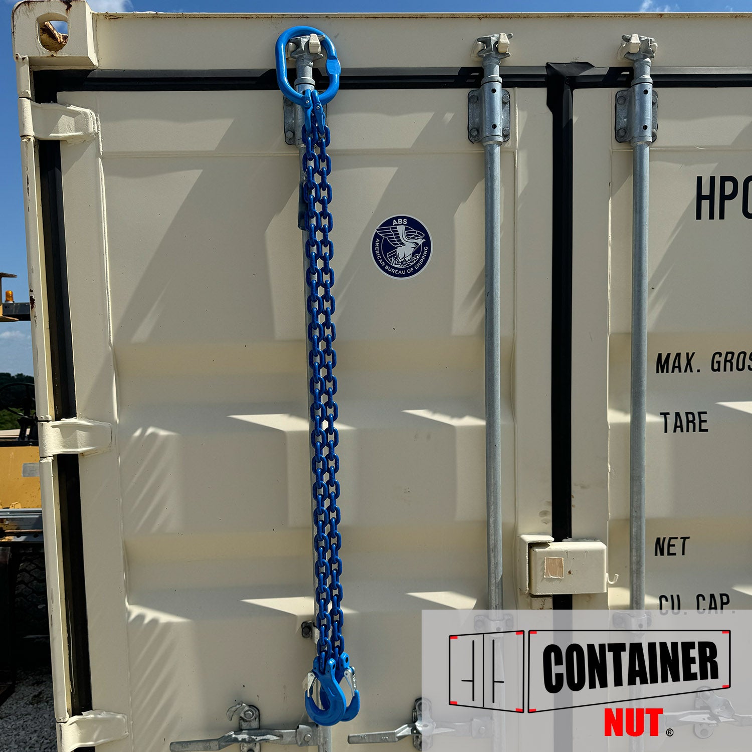 A white shipping container with metal fixtures on the door is secured with a Chain Sling. The container features a logo in the upper center labeled "HP" along with other specifications. In the bottom right corner, there's a logo for Container Nut.