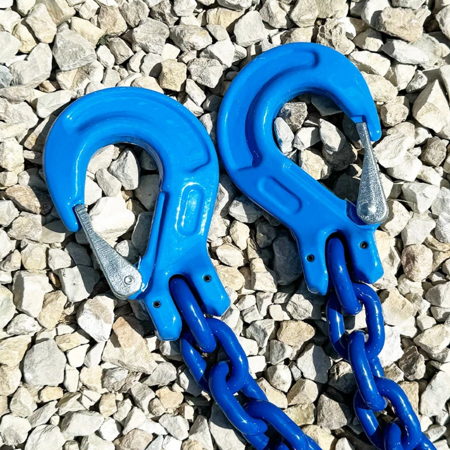 Blue Chain Sling with G100 Clevis's Hooks up to 15,200 lbs on gravel road.