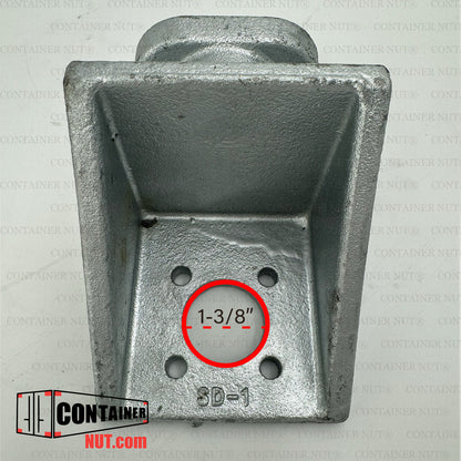 A close-up image of a galvanized twist lock fitting for a shipping container. The fitting is rectangular and has four bolt holes at the base. The measurement "1-3/8" is displayed in a red circle over one of the holes. A logo reads "ContainerNut.com".